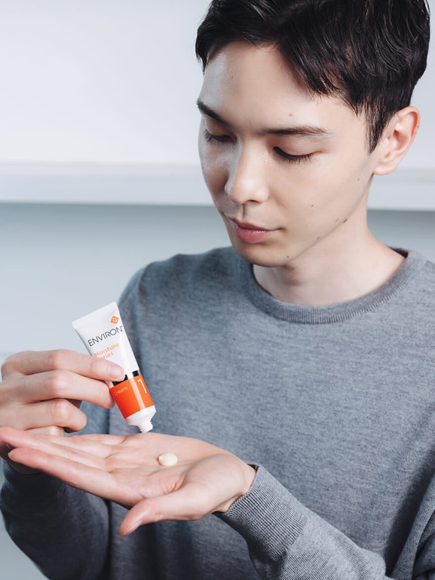 エンビロンのモイスチャークリーム(保湿クリーム)を手に取るメンズノンノモデルの守屋光治さん