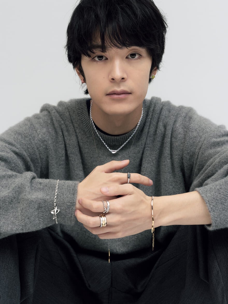 ete(エテ)の2025年秋冬の新作ジュエリーを着用する俳優の塩野瑛久さん グレーのニットにコーディネート