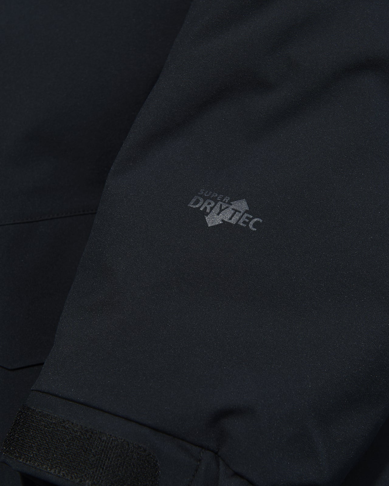 モンベルの黒いパウダーランド パーカの袖口のロゴ