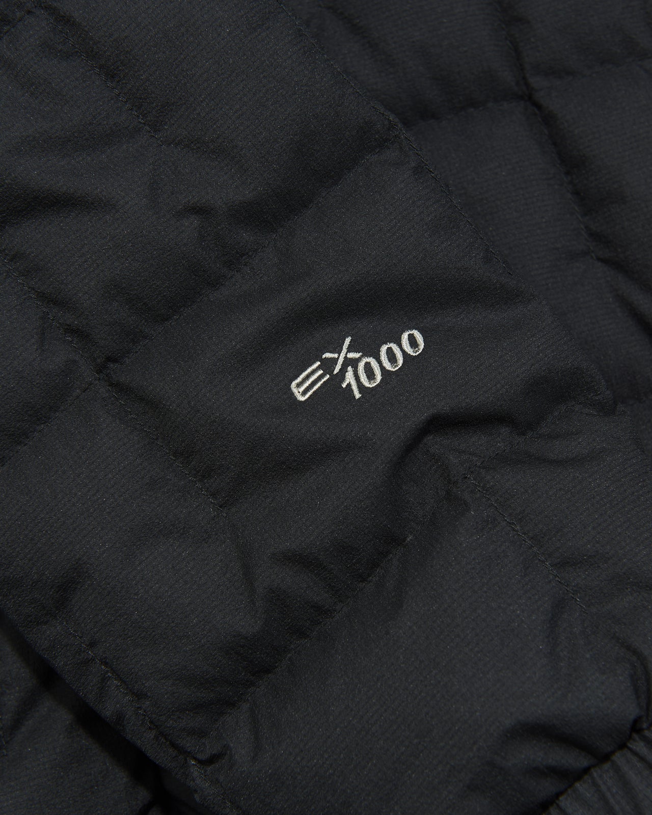 モンベルの黒いイグニスダウン パーカ ジャケットの袖元の刺繍