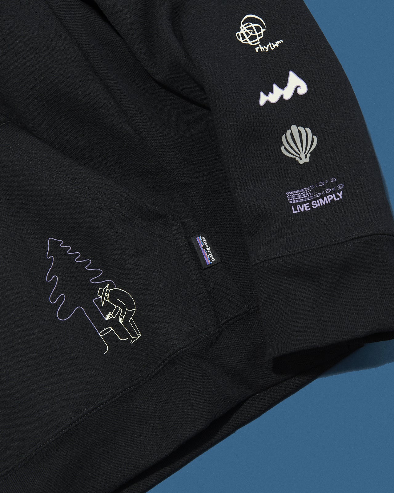 パタゴニアのロング・ウェイ・ラウンド・アップライザル・フーディのロゴ