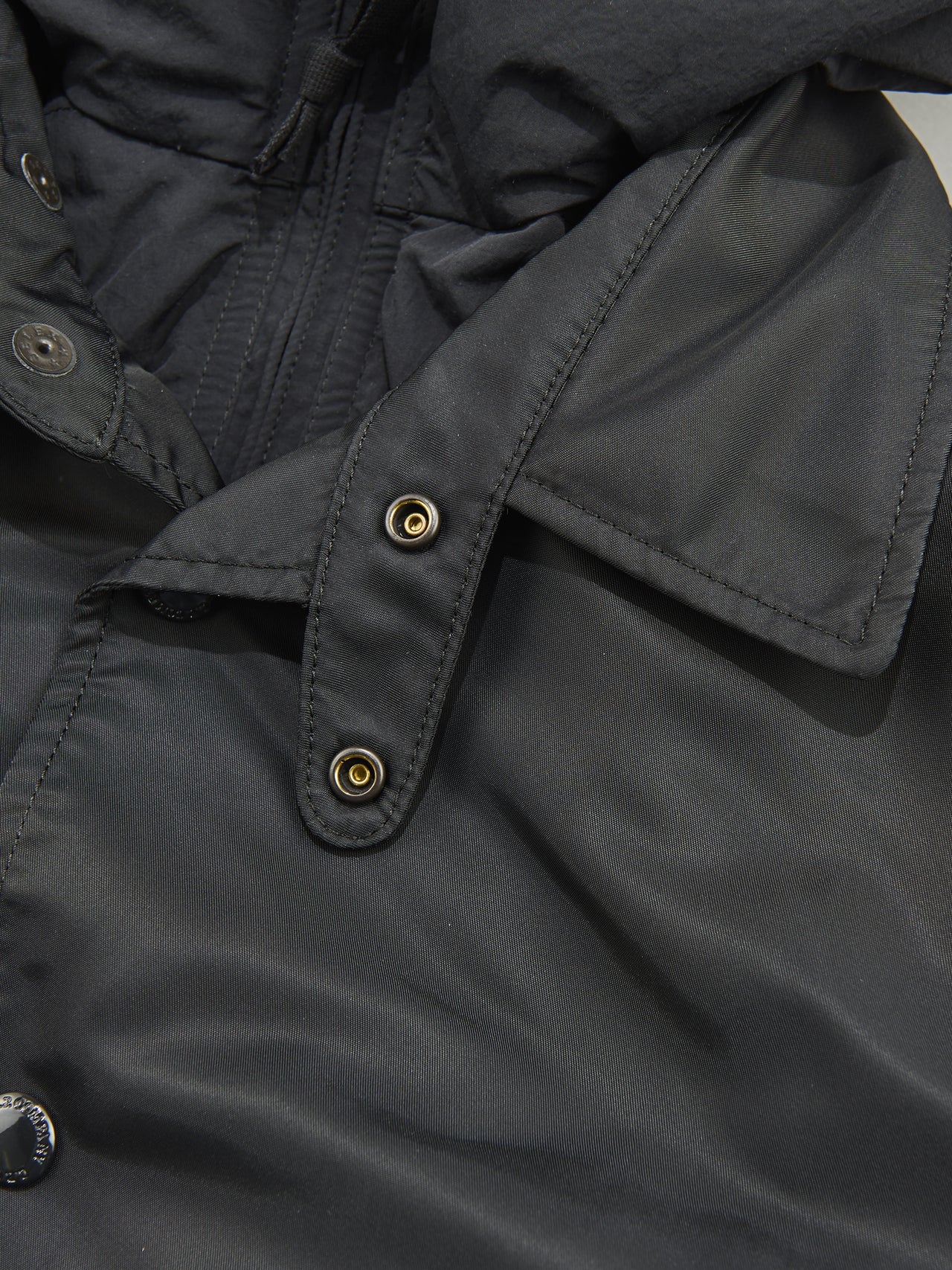 eYe ジュンヤ ワタナベ マンとC.P.COMPANY(シーピー・カンパニー)の黒いコラボダウンジャケットのチンストラップ