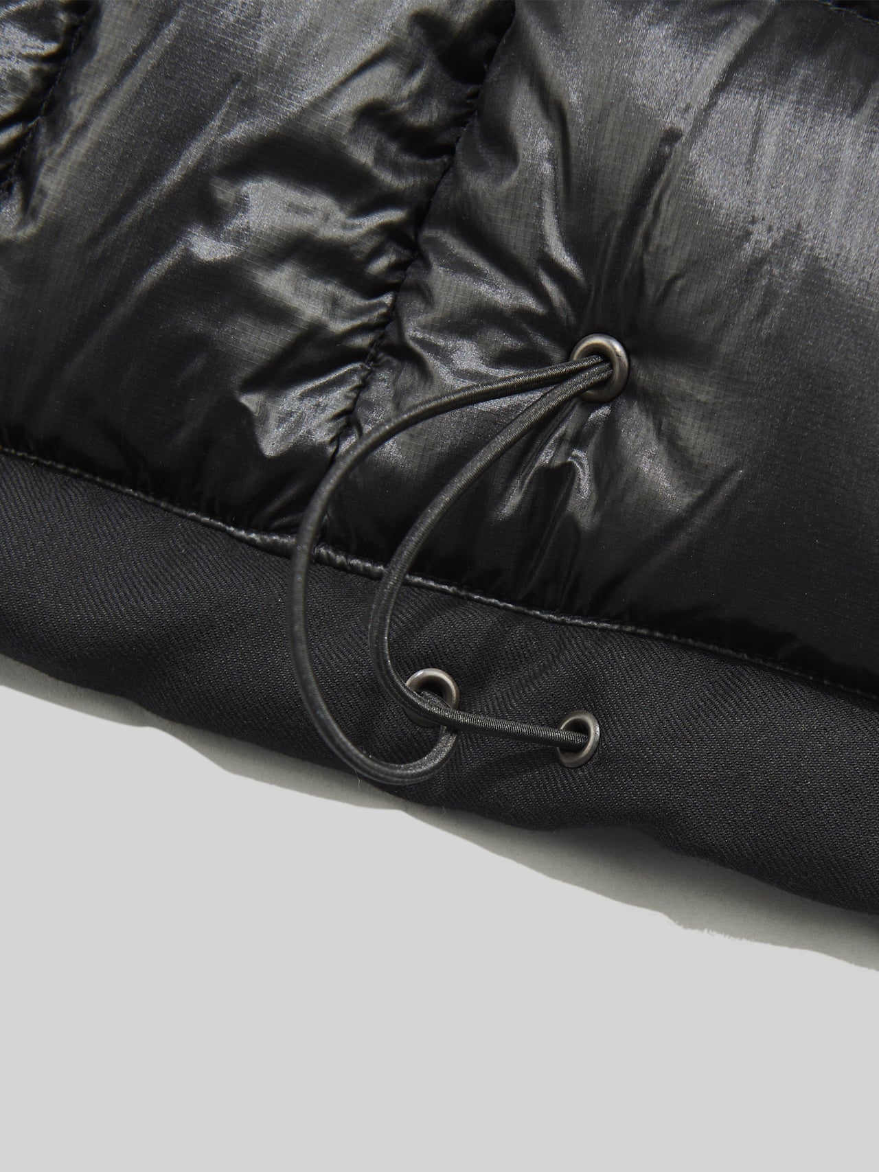 eYe ジュンヤ ワタナベ マンとナンガの黒いコラボダウンジャケットの裾コード