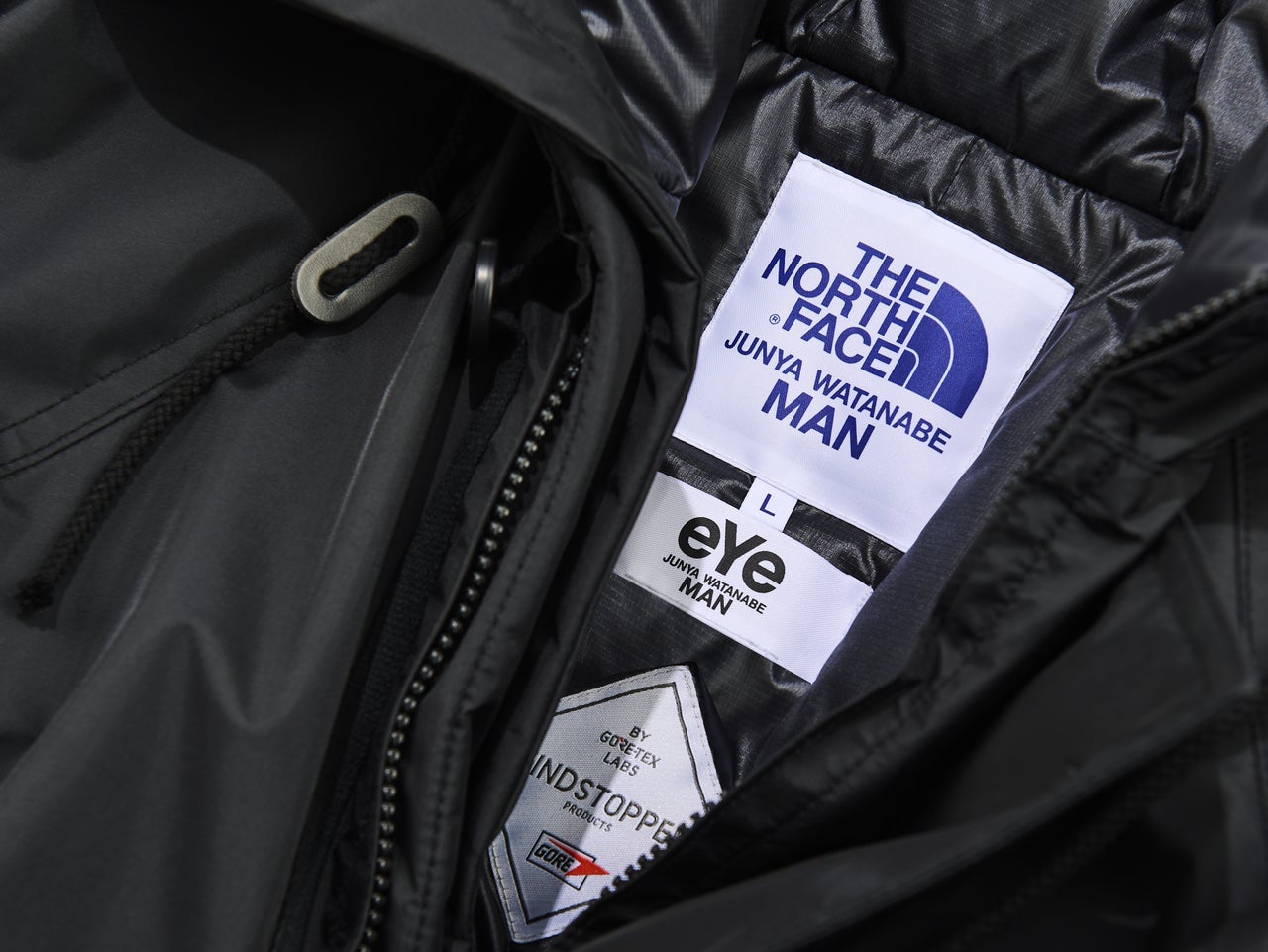 「eYe ジュンヤ ワタナベ マン」×「ザ・ノース・フェイス」のコラボジャケットのロゴ寄り
