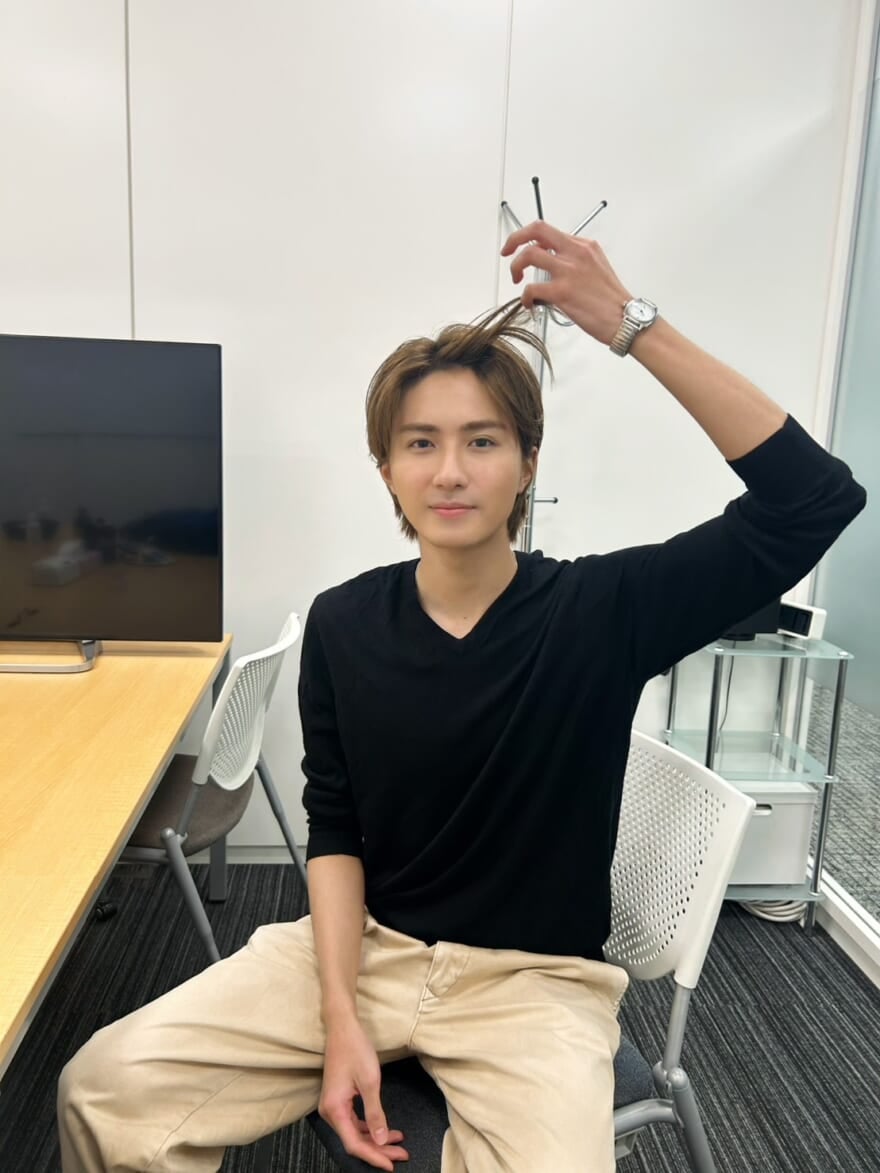 部屋の中にいるメンズノンノモデル髙橋大翔。染めた金髪を指で摘んで見せている。