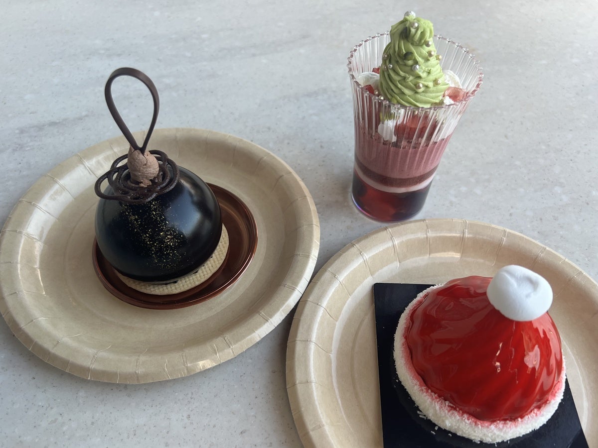 クリスマス・パフェ 〜ベリー＆ピスタチオ〜¥900 ベリー系のムースをベースにした美しい層が映えるクリスマスパフェ。 （右）サンタクロース 〜キャラメル＆ラズベリー〜¥900 真っ赤なサンタの帽子をココナッツでおめかし。見た目も可愛いキャラメルケーキ！ （左）ムースオショコラ 〜オランジェ＆カルダモン〜¥950