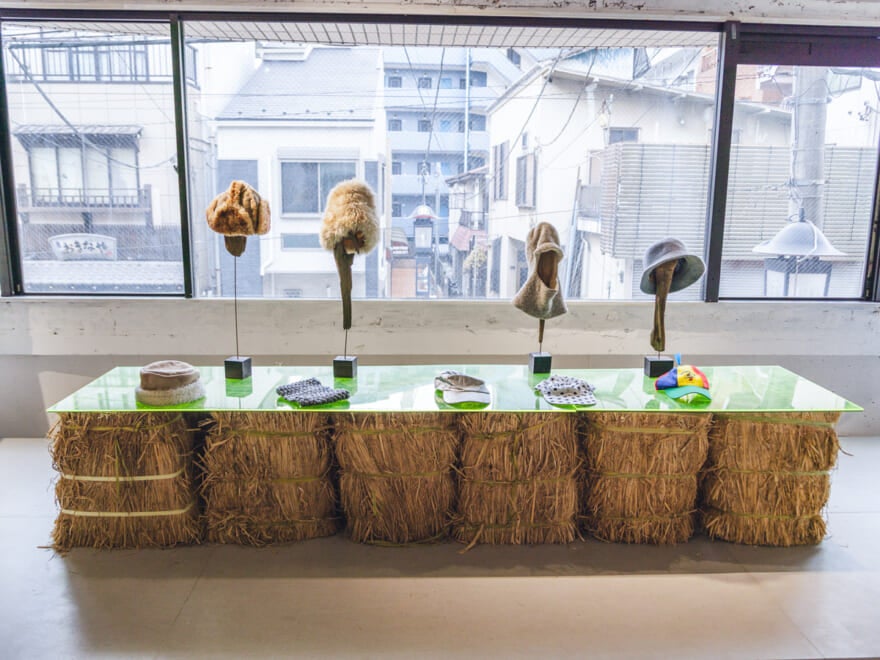 古着店ヨウランの店内。窓の前に置かれたテーブルに帽子が並べられている。