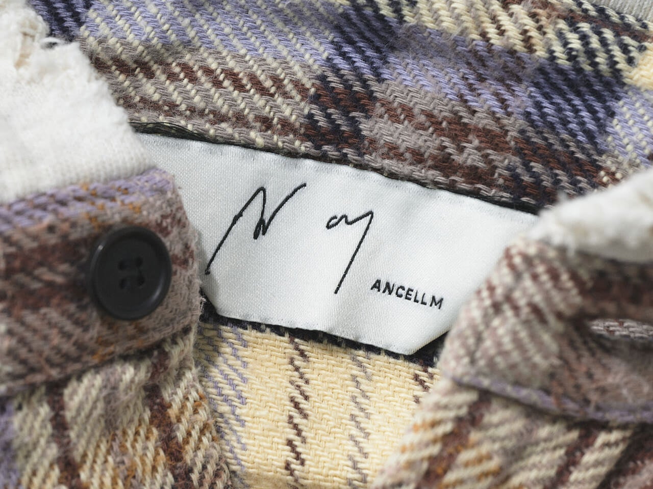 エディターが買ってよかった「アンセルム」のフードつきチェックシャツのタグ寄り