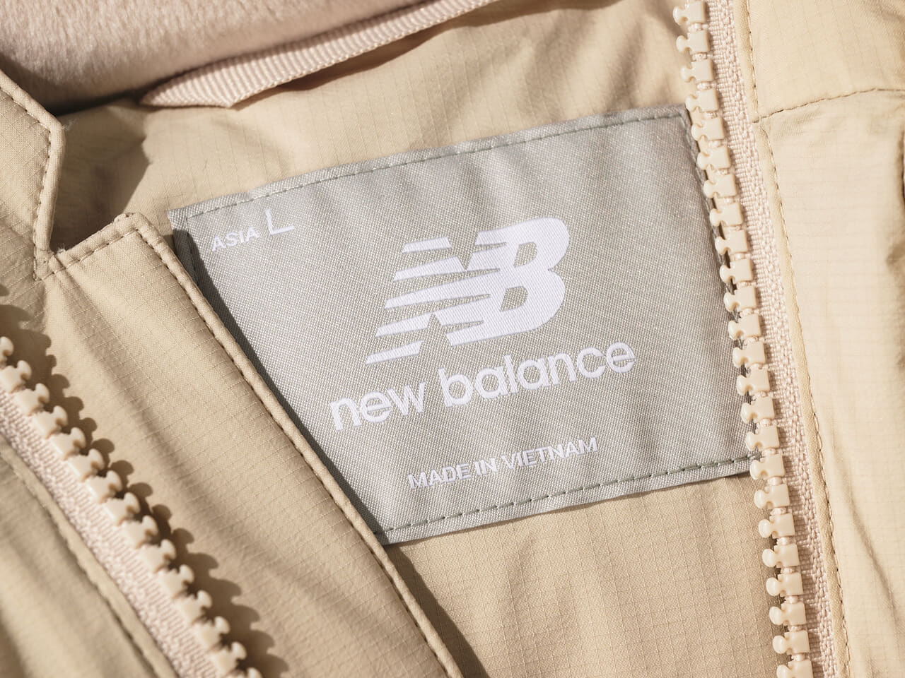 エディターが愛用するニューバランスのNB GREY ダウン ベストのタグ