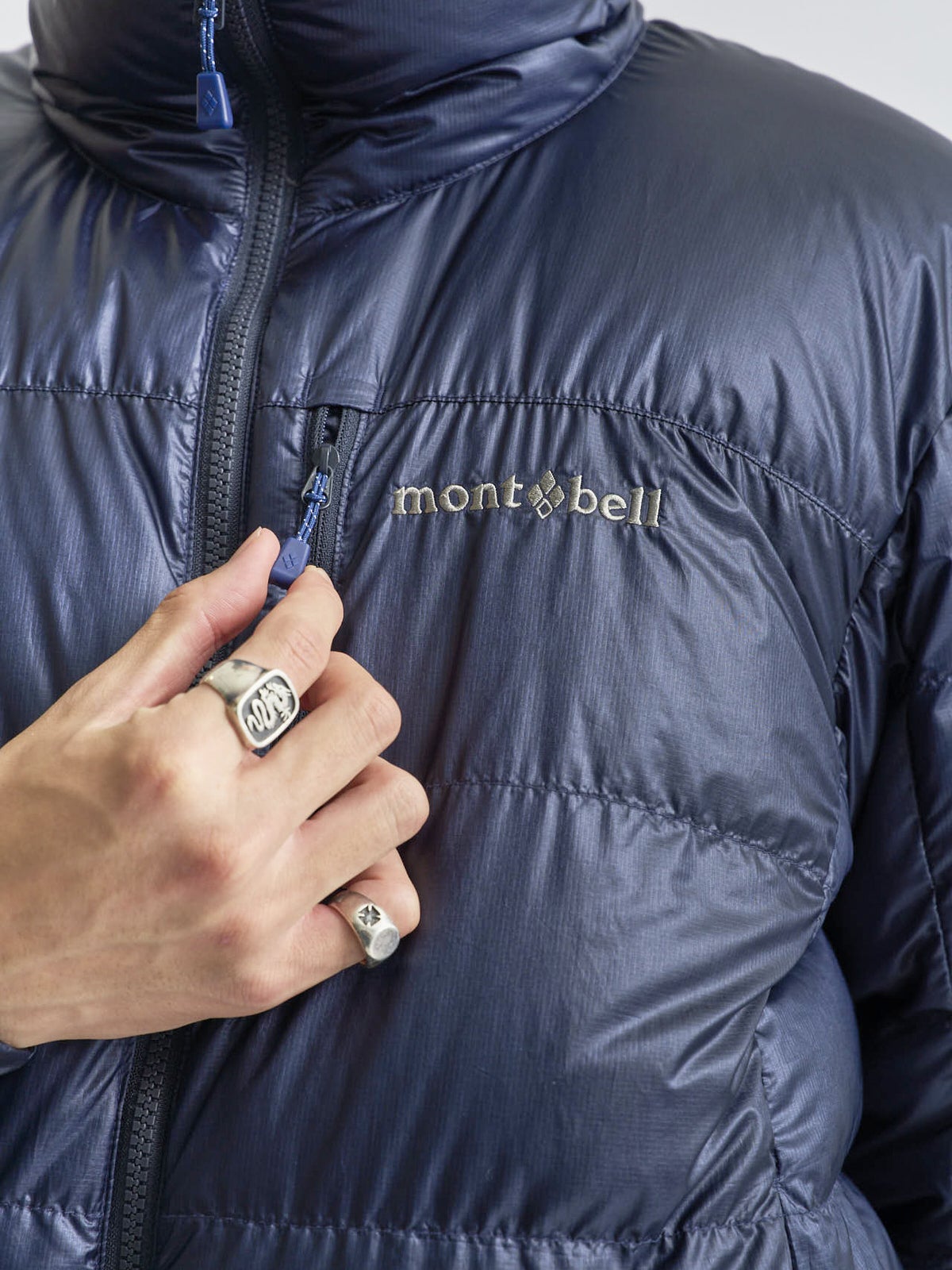 モンベルのアルパインダウン ジャケットのオシャレな着こなしのロゴ部分