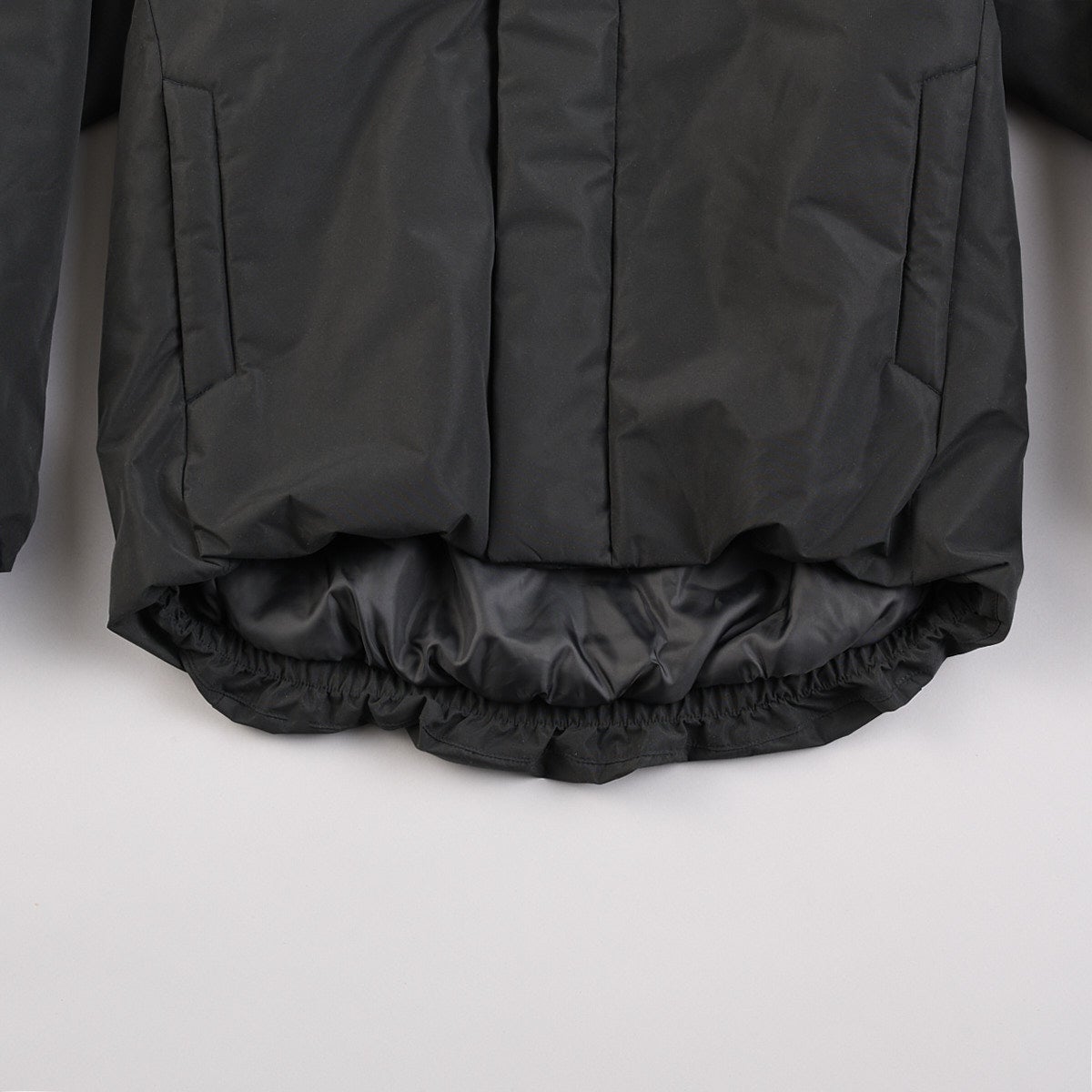 無印良品の黒い紳士 防風撥水中わたフードジャケットの裾