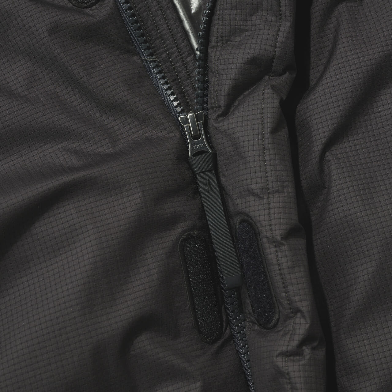 ゴールドウィン ゼロの黒いウィンドストッパーモパデッドジャケットのジップ