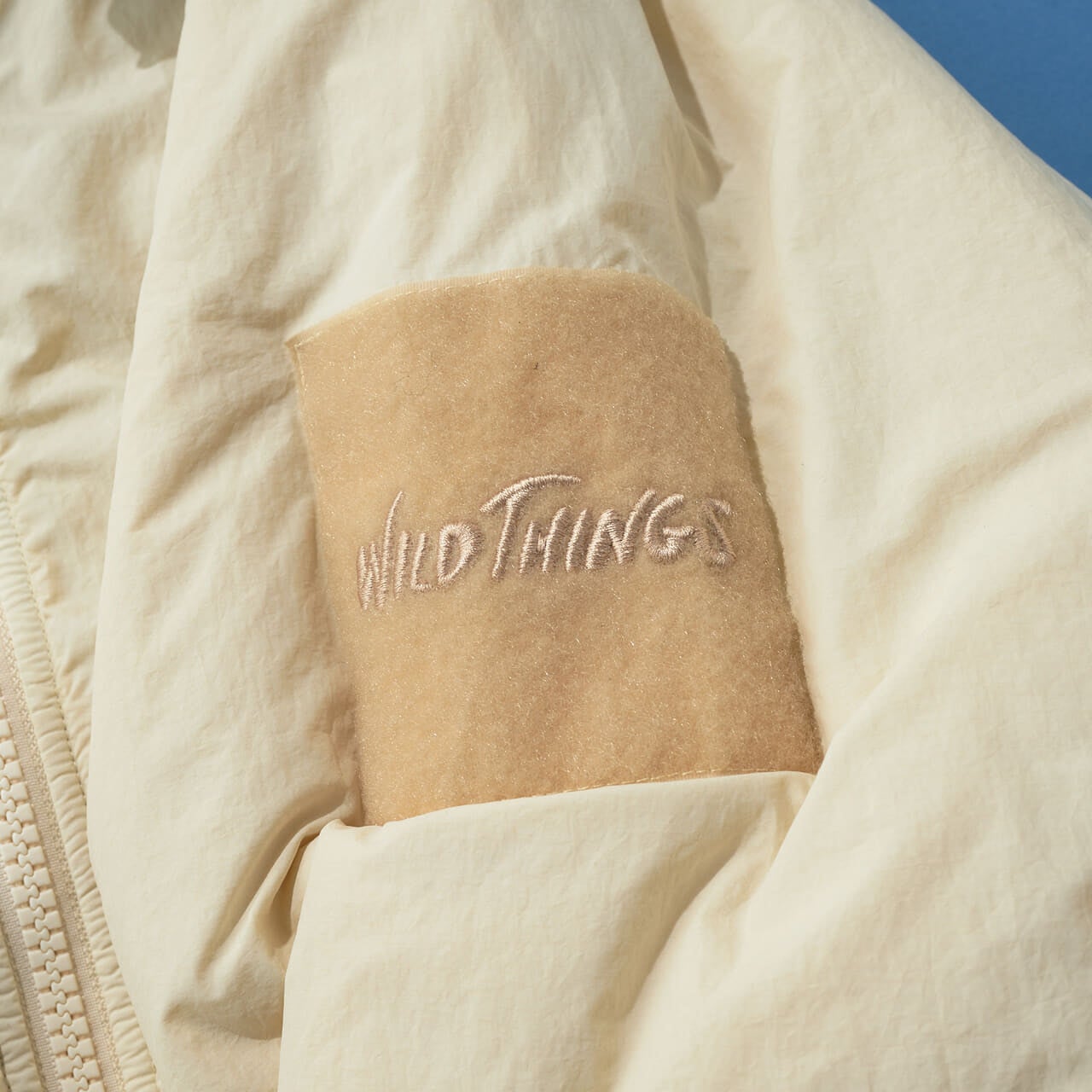 エフシーイーとワイルドシングスのコラボ機能中綿アウターの袖ロゴ