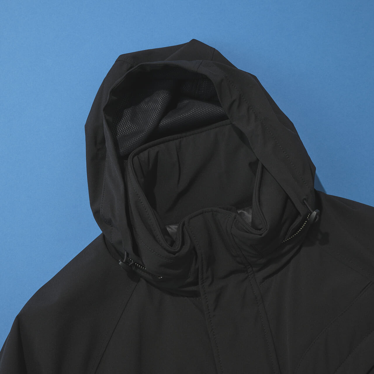 ストーンアイランドの黒い中綿ジャケットのスタンドカラーのフード出したバージョン