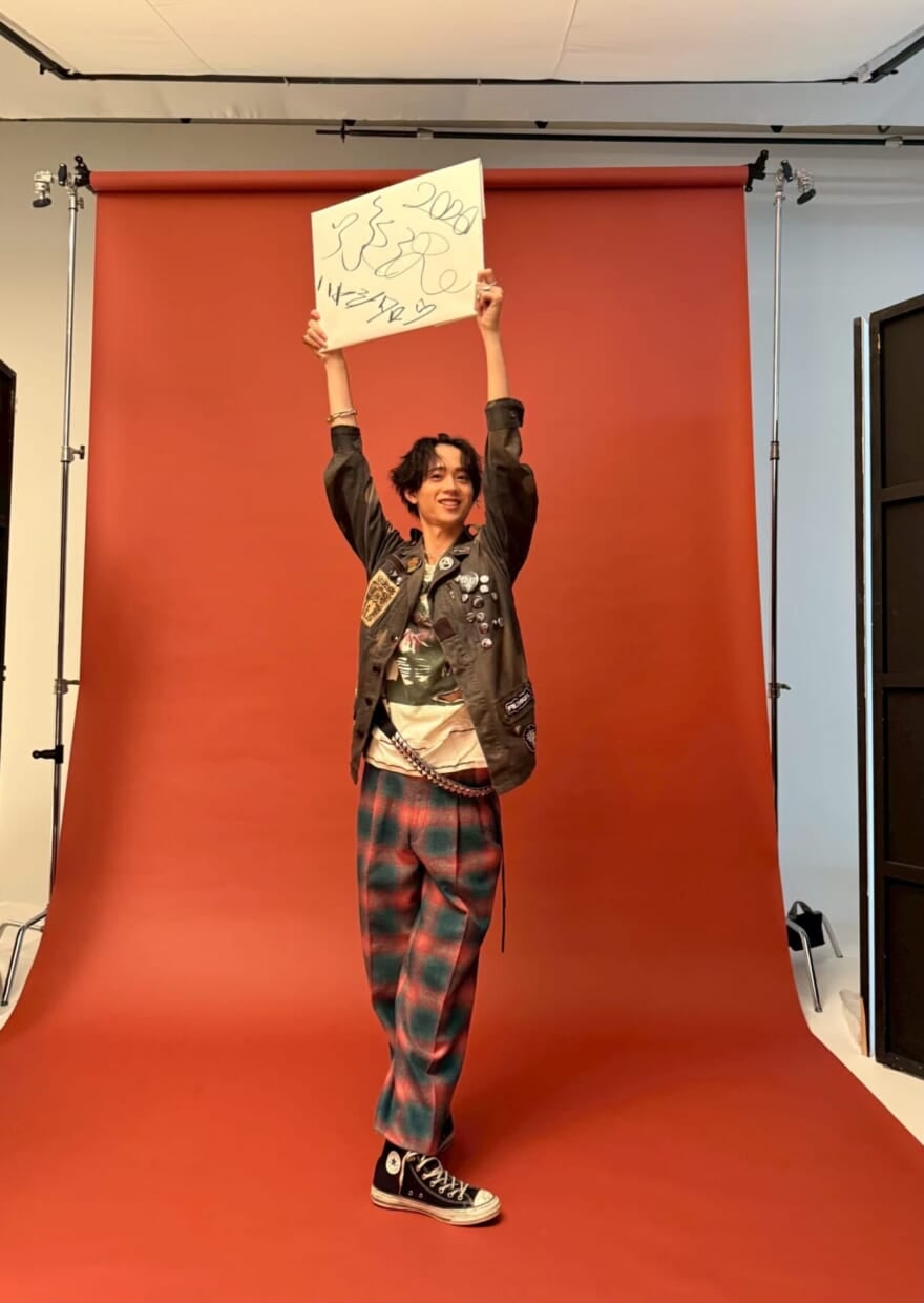 スケッチブックを高く掲げるメンズノンノモデル水沢林太郎