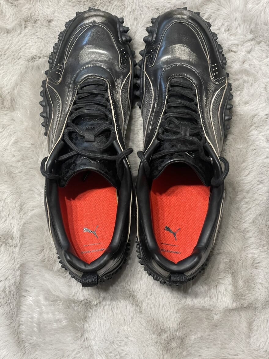 「ガディッド アノニム」と「プーマ」がコラボした"MOSTRO XC(モストロ XC)"のアッパー。靴底が赤い。
