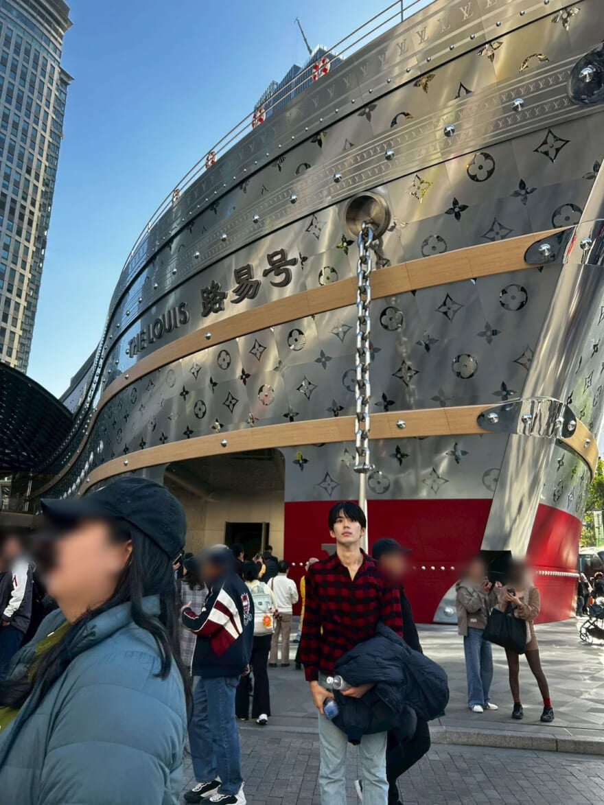 中国にいる稲井孝太朗。大きな船の間に立っている