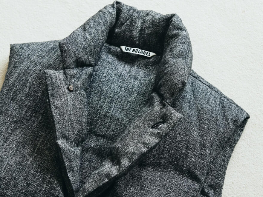 シンプルコーデはダウンベストと「アシックス」の黒スニーカーで引き立てる。[NULABEL]