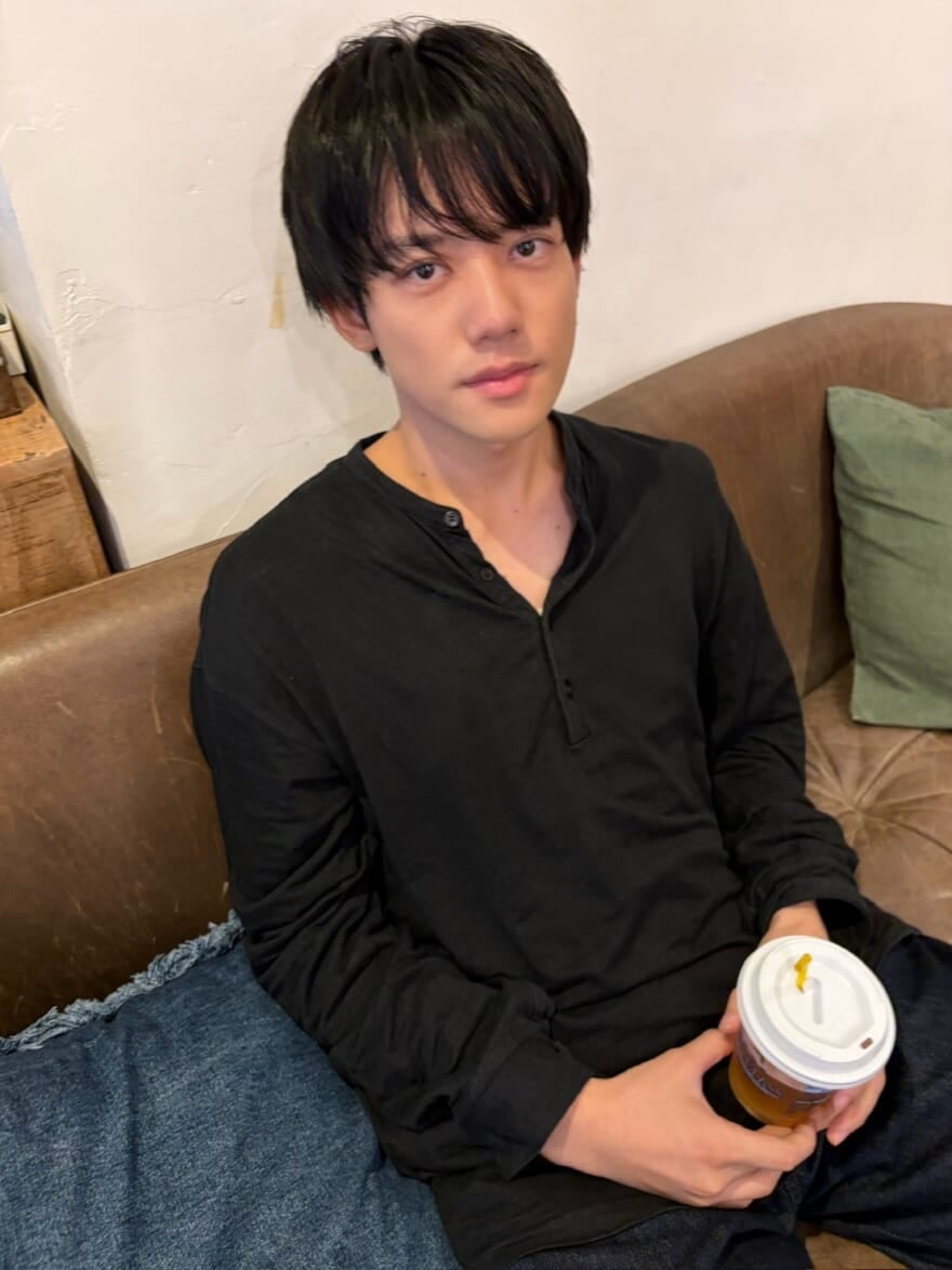カフェの紙カップを手に持ったメンズノンノモデル樋之津琳太郎