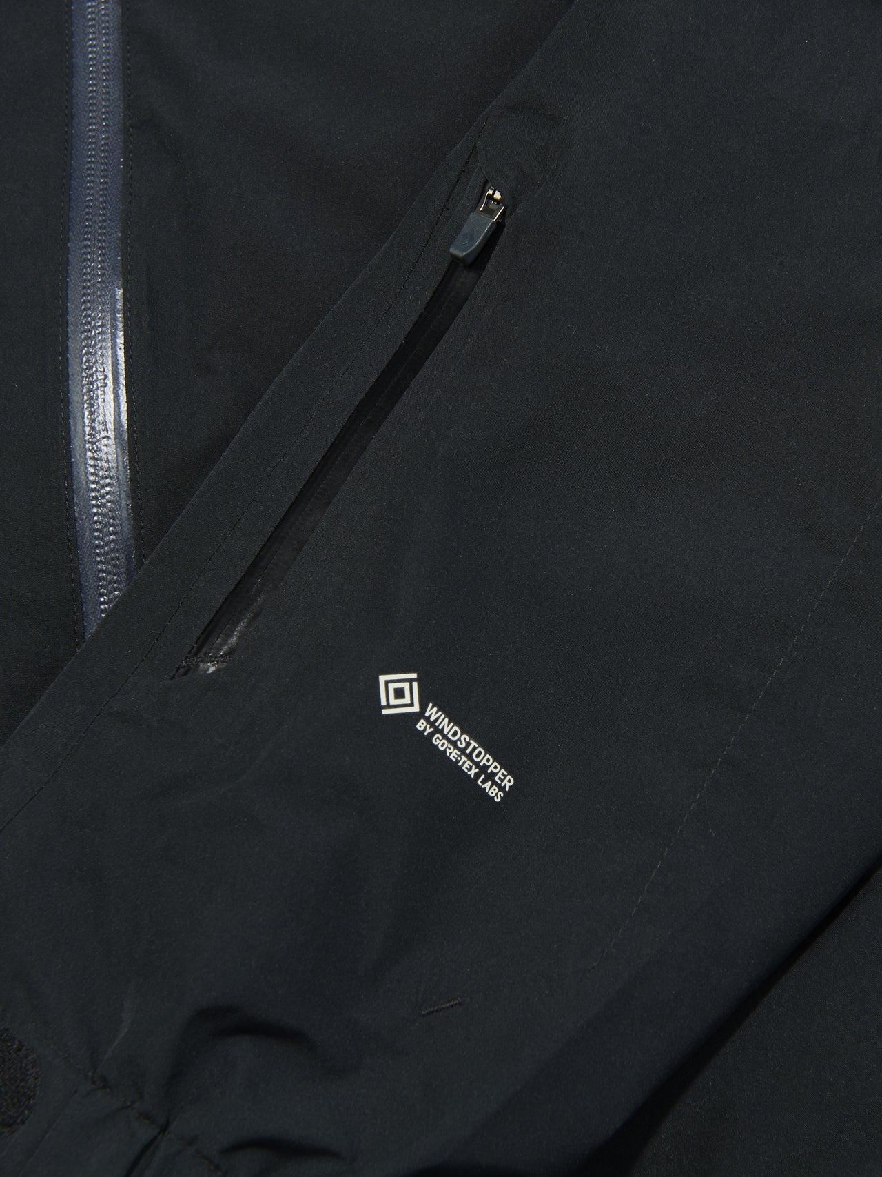 モンベルの黒いシェルゴアテックスジャケット/パウダーグランドパーカのロゴ