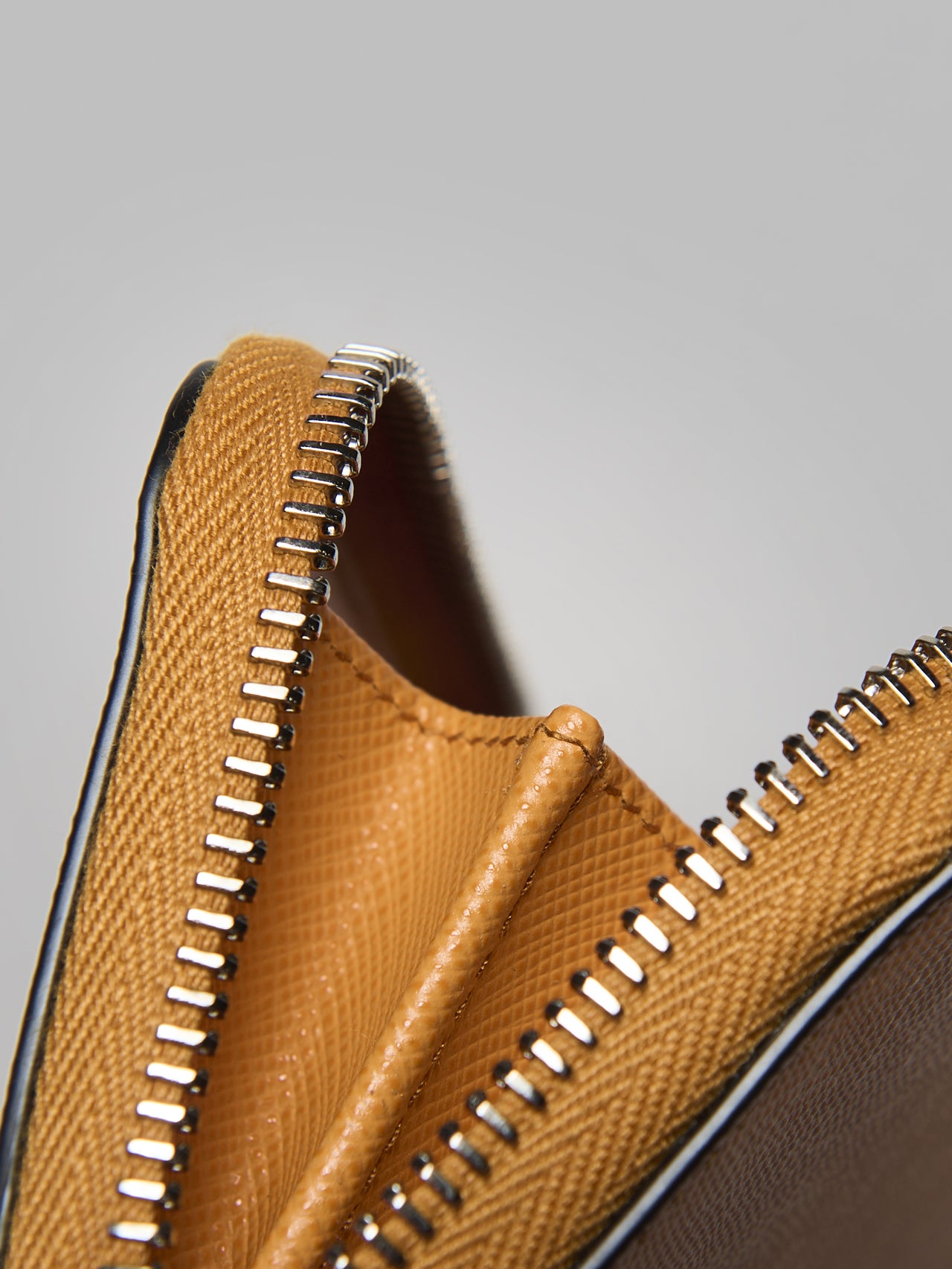 プラダの新作革財布「サフィアーノ」トライアングル コインケース ウォレットのジッパー、コバの寄り