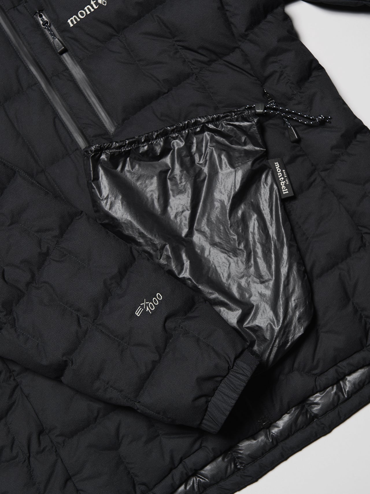 モンベルの黒いイグニスダウン パーカ ジャケットのスタッフバッグ、1000フィルパワー・EXダウン