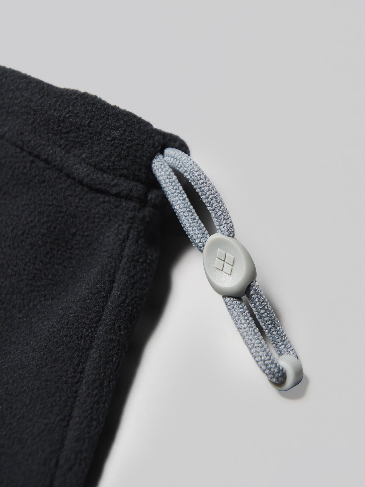 モンベルの黒いシャミース アジャスタブルネックゲーターのドローコード