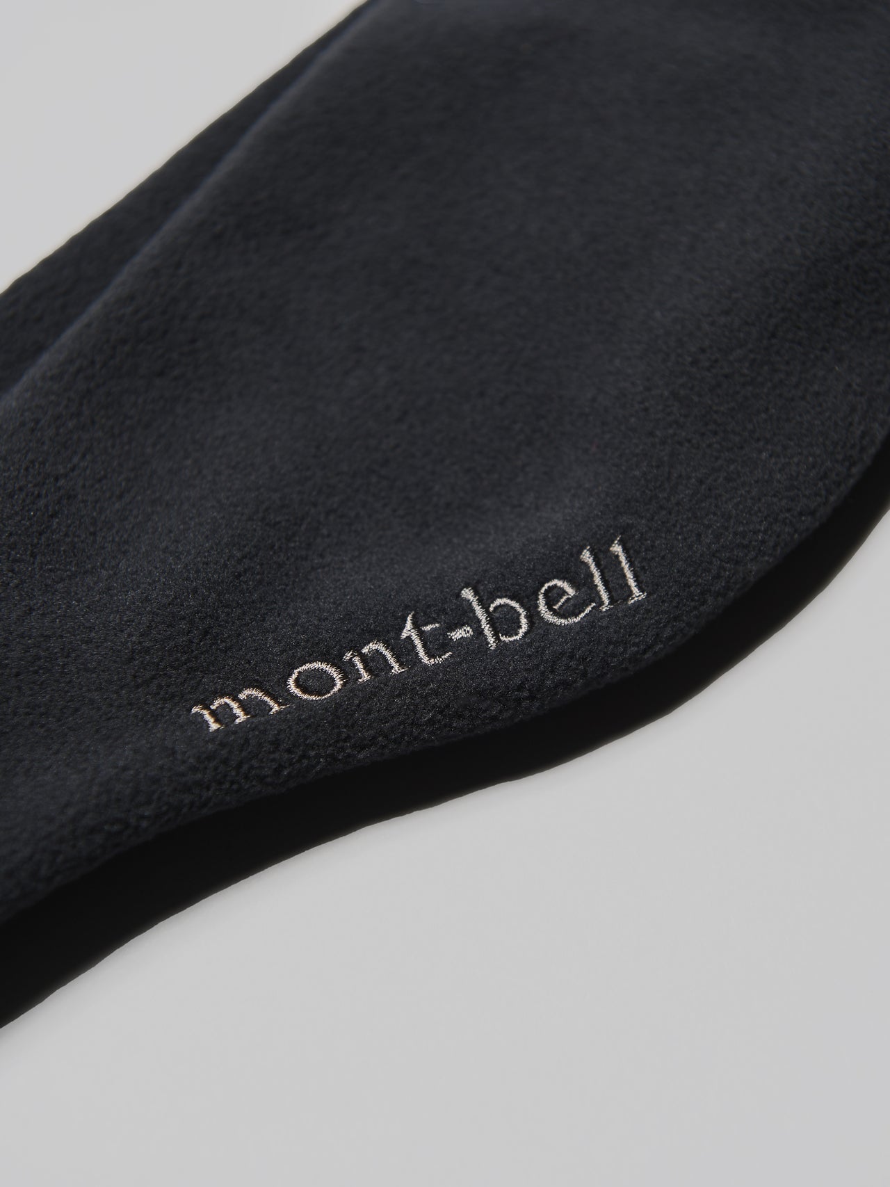 モンベルの黒いシャミース ヘッドバンドのブランドロゴ