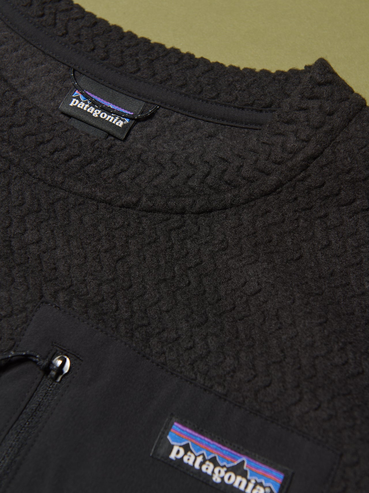 パタゴニアの黒いメンズ・R1 エア・クルー シャツのクルーネック、ブランドロゴ