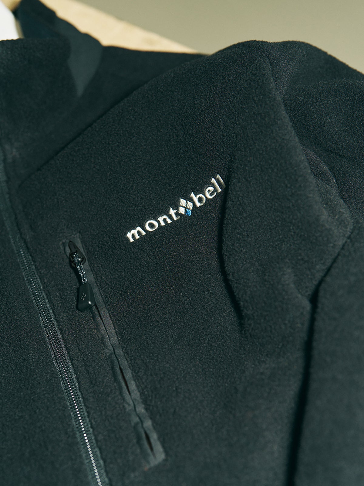 モンベルのクリマプラス200 ライニングジャケットの胸ジップとロゴ