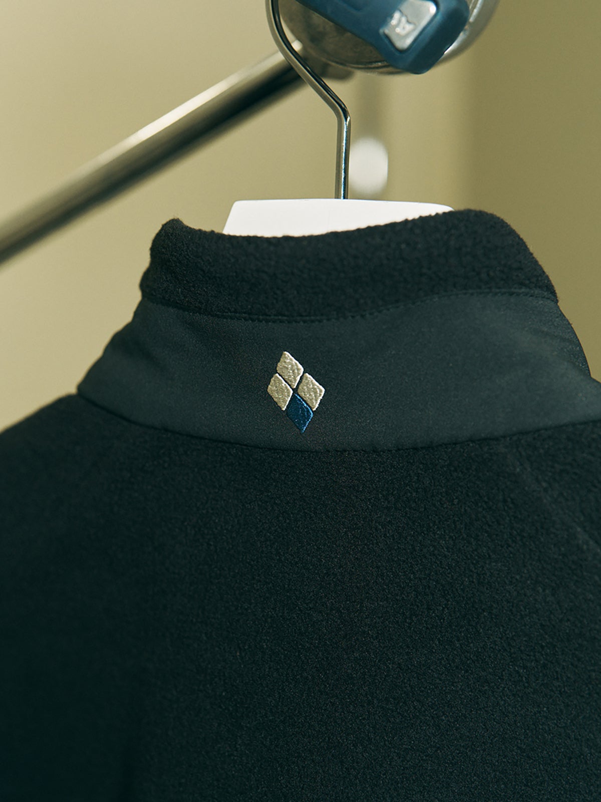 モンベルのクリマプラス200 ライニングジャケットのスタンドカラーとブランドロゴ