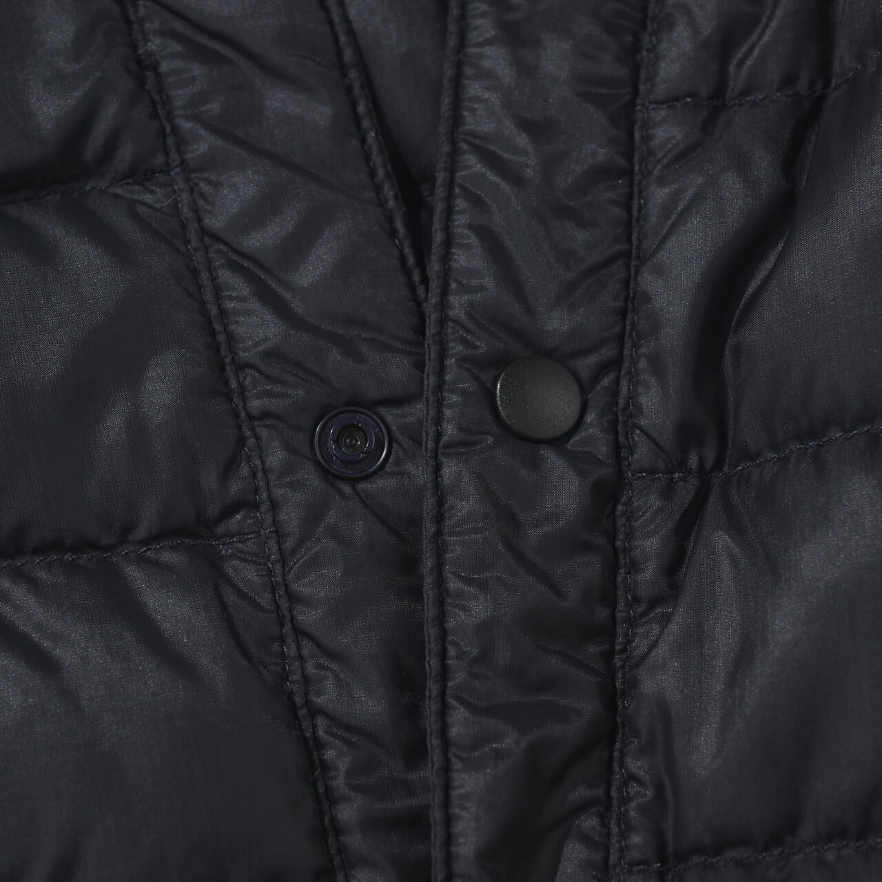 エディターが愛用するモンベルの黒い薄軽インナーダウンのスナップボタン