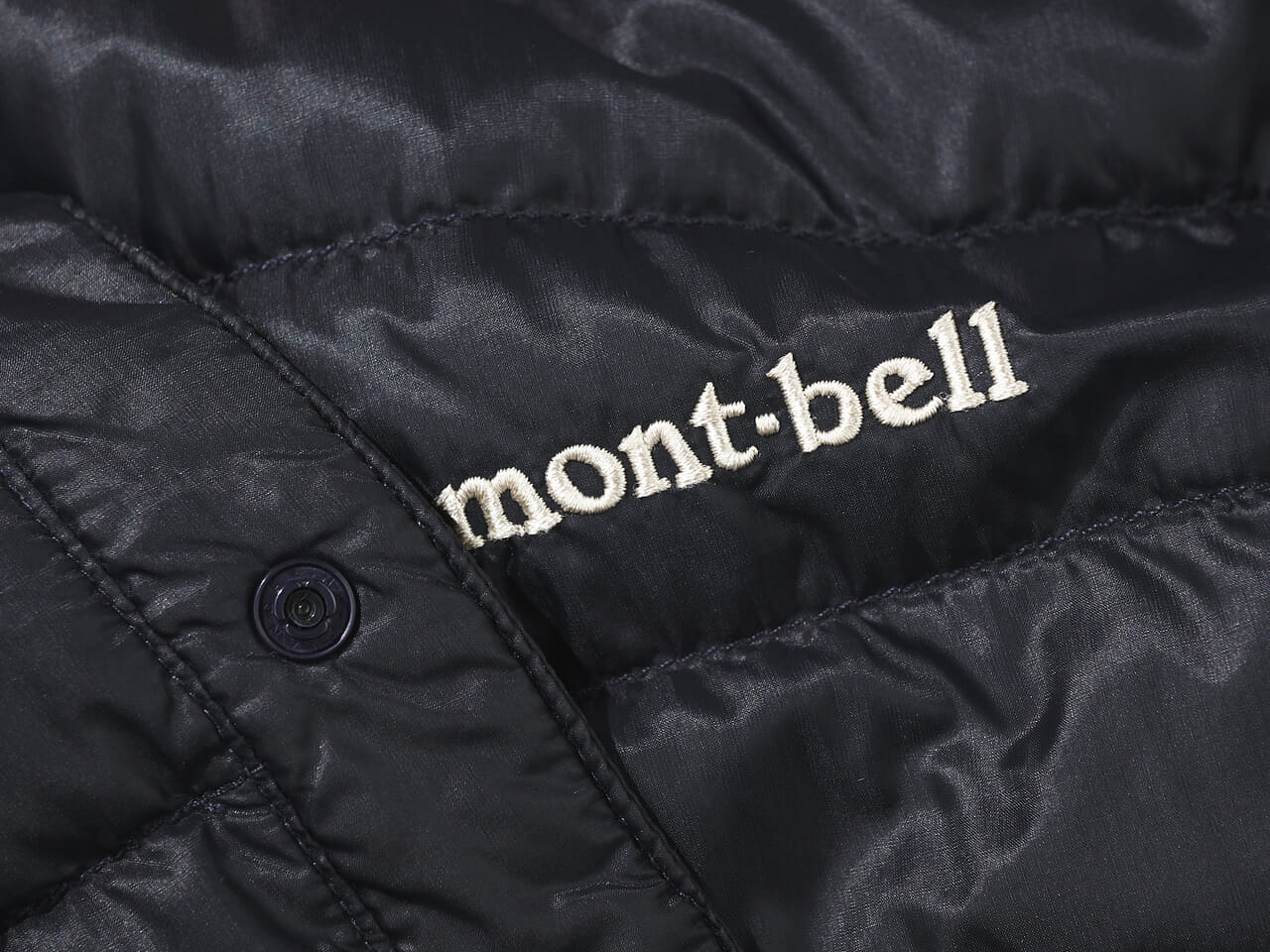 エディターが愛用するモンベルの黒い薄軽インナーダウンのロゴ