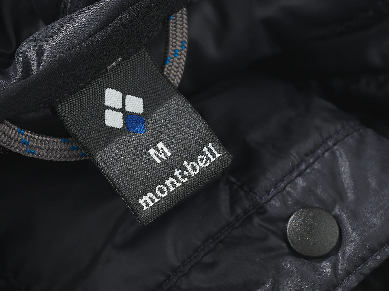 エディターが愛用するモンベルの黒い薄軽インナーダウンのタグ