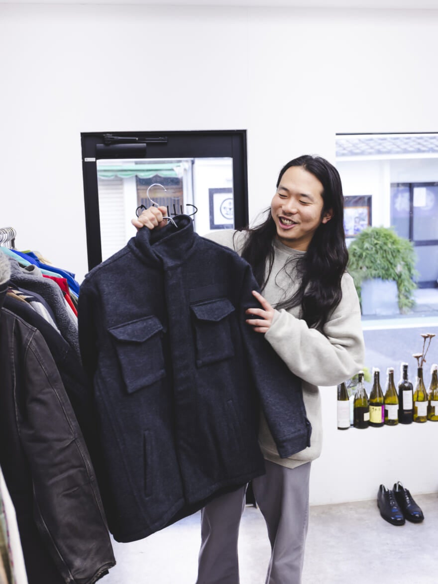 チャコールグレーのジャケットを手にとる荒幡さん