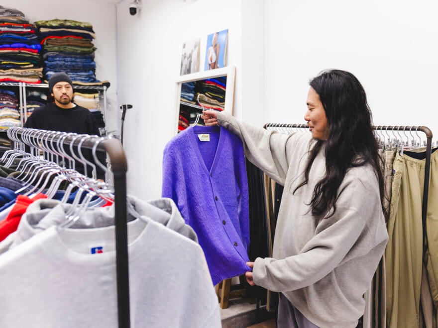 モヘアカーディガンを手に取るスタイリスト荒幡さん