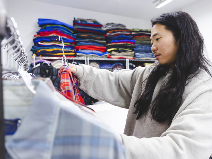 チェックシャツを手にとる荒幡さん