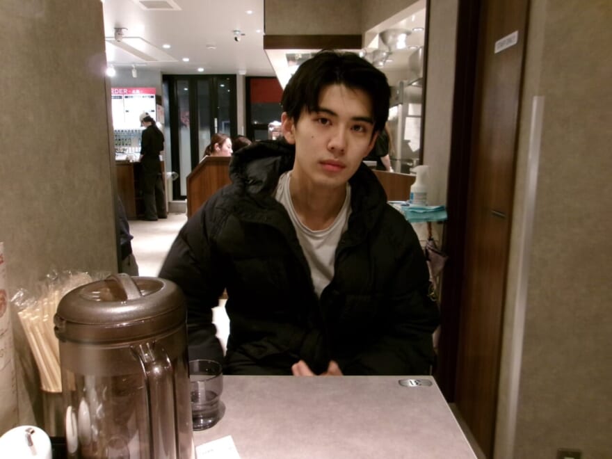 料理店のちいさなテーブルに収まる稲井孝太朗