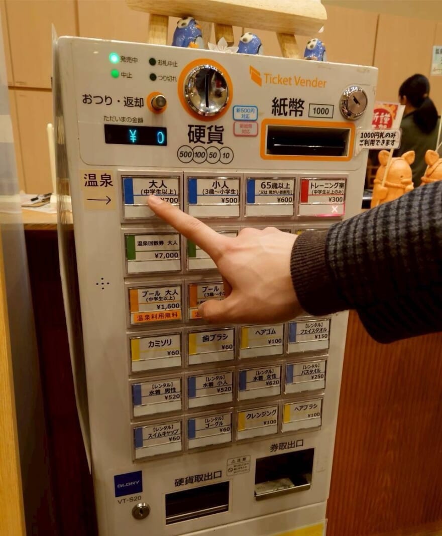 温泉の券売機。「大人」のボタンを押している。