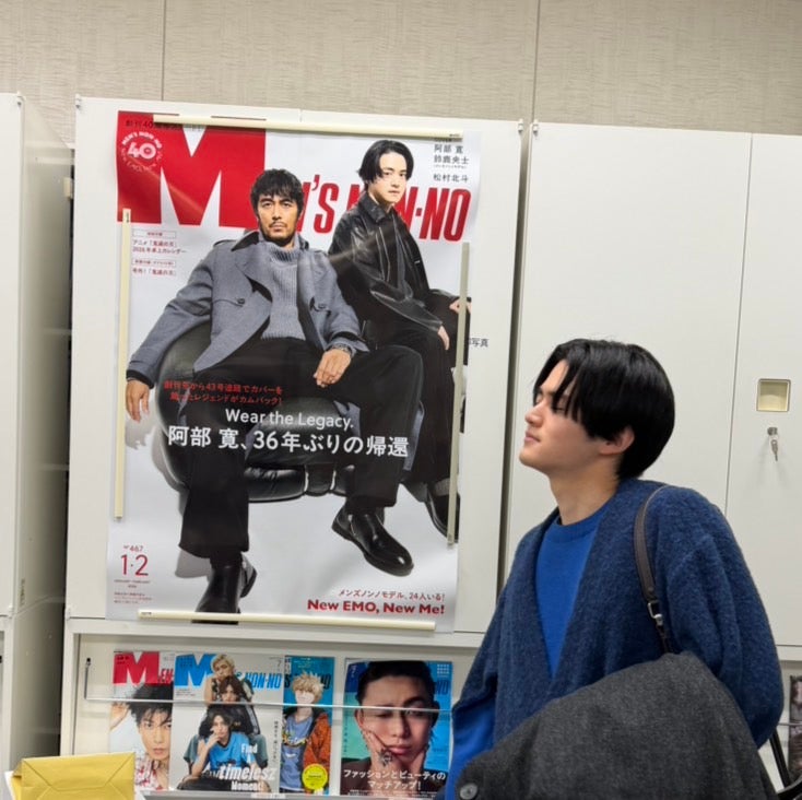 棚に貼られたポスターの前で感慨深げに佇む鈴鹿央士