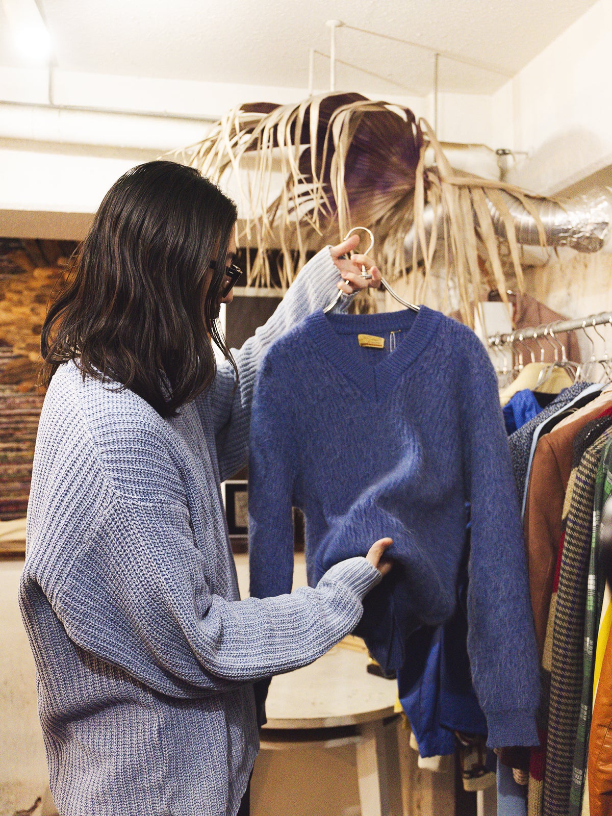 青いニットを手に取る大澤さん