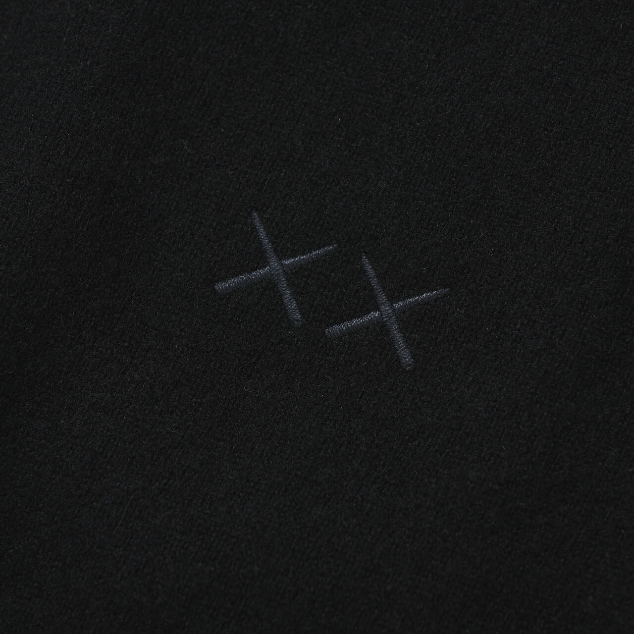 エディターが買ってよかったユニクロの愛用コラボ黒ニット／カウズ ウィンター カシミヤクルーネックセーターのロゴ