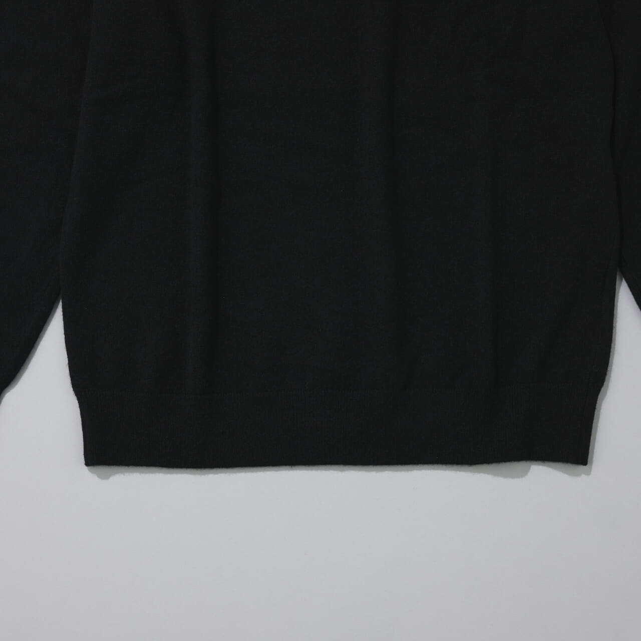 エディターが買ってよかったユニクロの愛用コラボ黒ニット／カウズ ウィンター カシミヤクルーネックセーターの裾