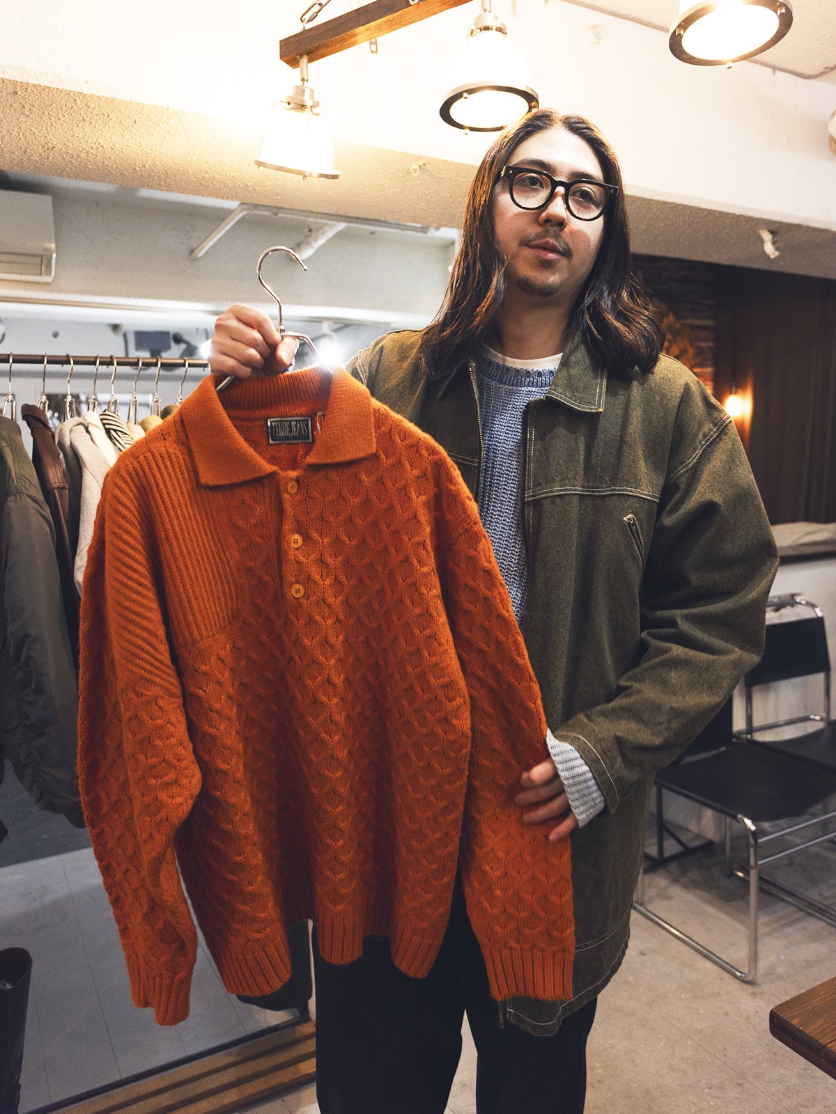 オレンジのニットを手に取る大澤さん