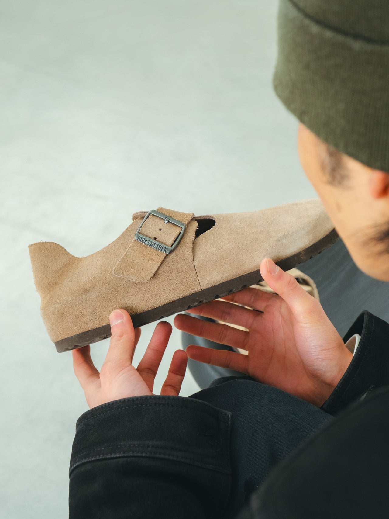 ビルケンシュトックの「ロンドン」を手に取る中田圭祐の手もと