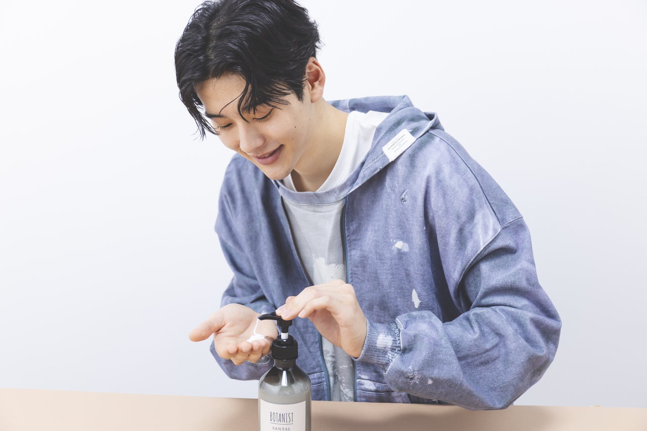 男性がコンディショナーを手に出しているイメージカット