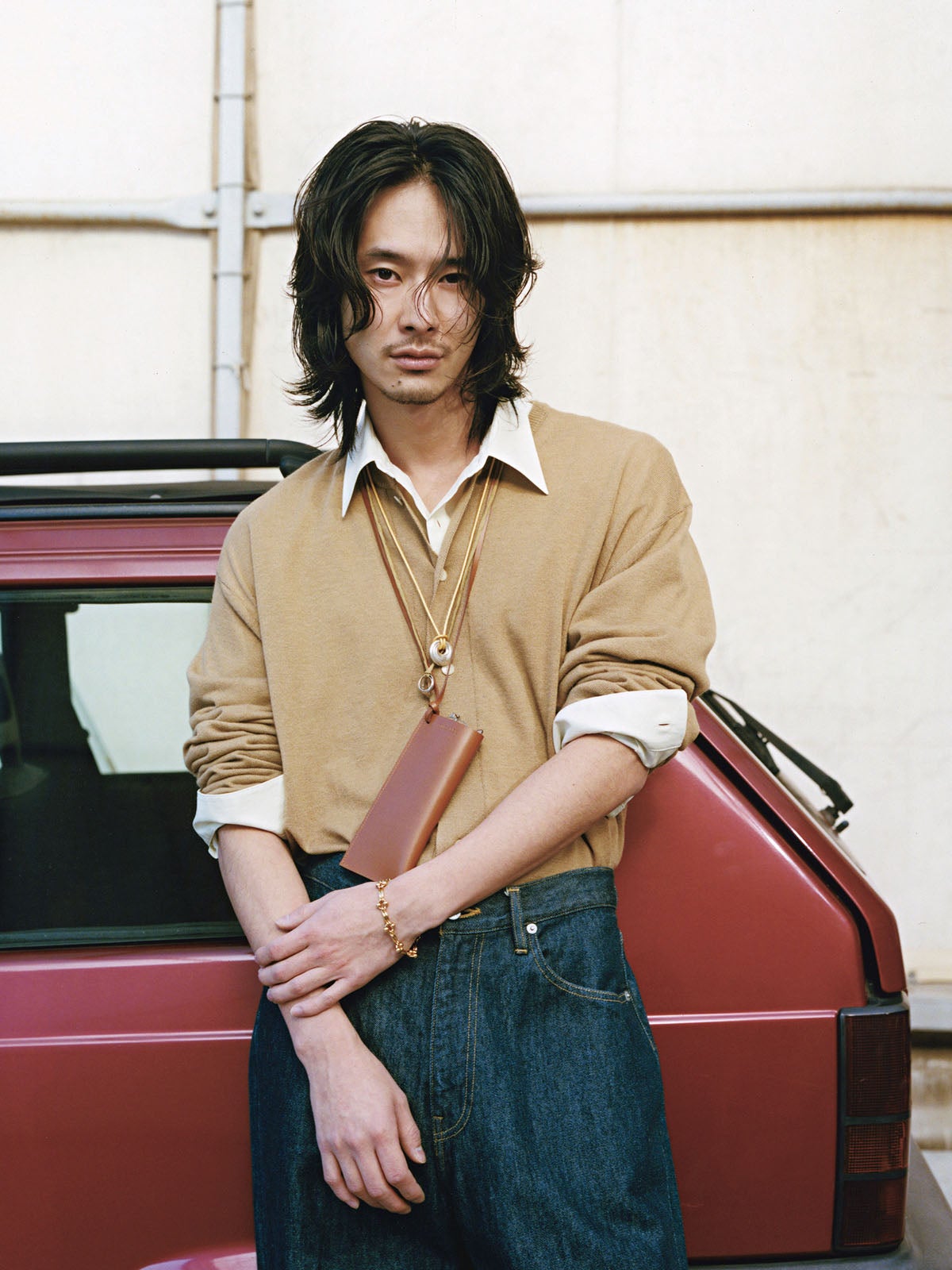 サンドベージュのニットカーディガン×ゴールドのジュエリーを重ね付けした着こなし