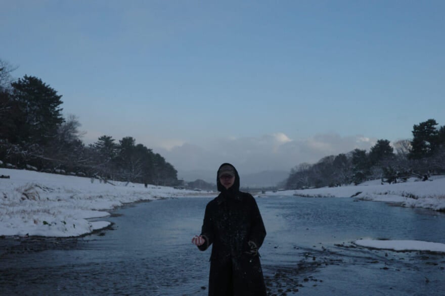 雪が降った日の京都。籠宮壮太朗の後ろに川が写っている