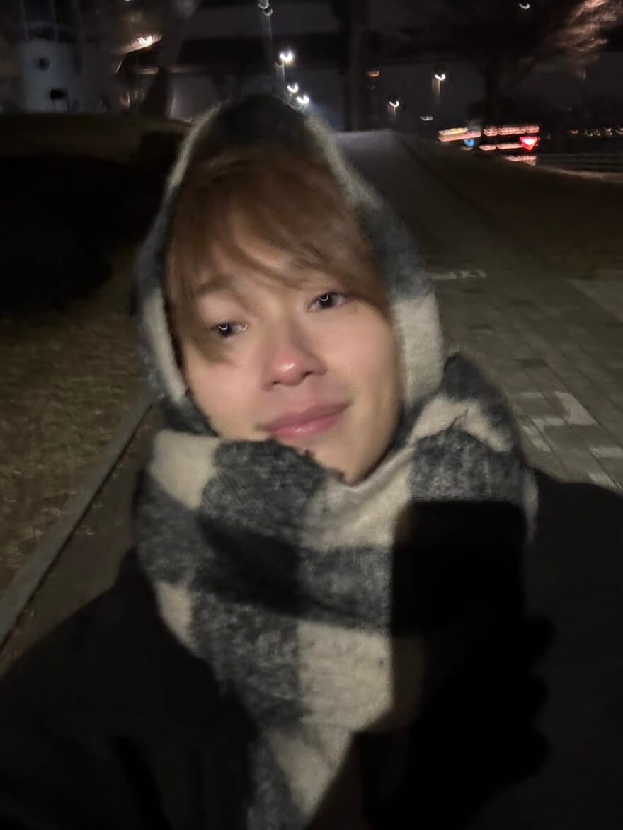 マフラーを巻いた野村康太。