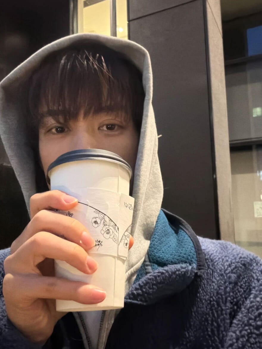 大きな紙カップでブラックコーヒーを飲んでいる樋之津琳太郎